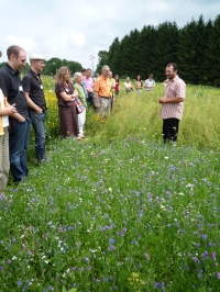 Landwirt Jürgen Wegmann mit interessierten Seminarteilnehmern inmitten seiner Blühenden Landschaft.